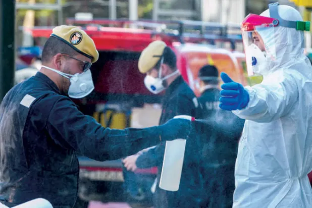 جنود يعقمون عمال صحة في زاراغوزا الإسبانية أمس (إ.ب.أ)