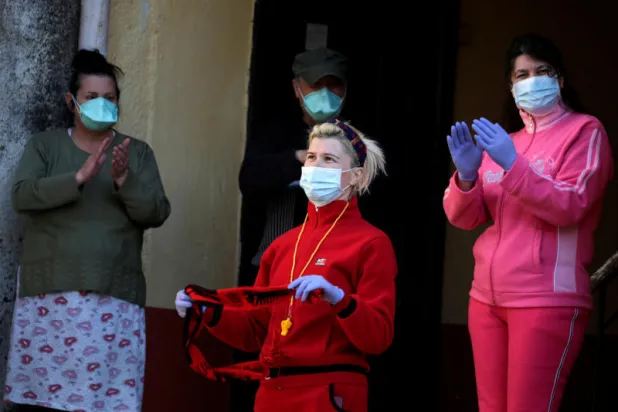 مغنّون بكمامات واقية...  حفل موسيقي ورقص فوق أسطح المنازل في ألبانيا (فيديو)