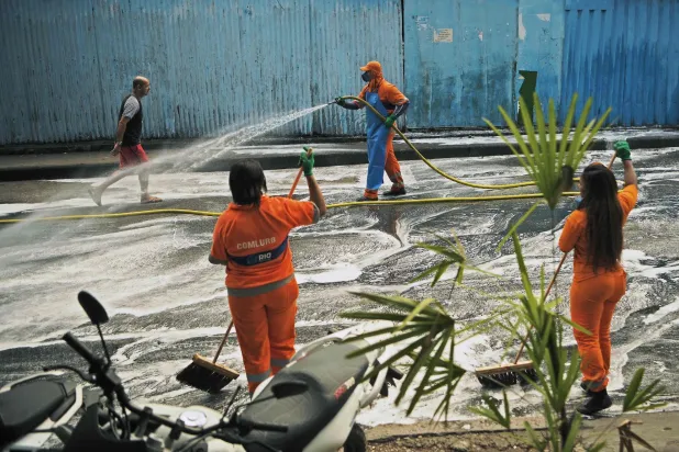 تعقيم شارع في مدينة ريو دي جانيرو البرازيلية (أ.ف.ب)