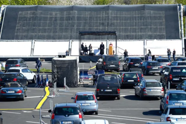 تحولت سينما للسيارات إلى كنيسة مؤقتة حيث حضر الجمهور في سياراتهم في مدينة دسلدورف الألمانية (رويترز)