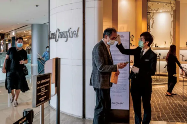 في متاجر لين كروفورد بهونغ كونغ العملاء والعمّال يخضعون لفحص درجات الحرارة (نيويورك تايمز)