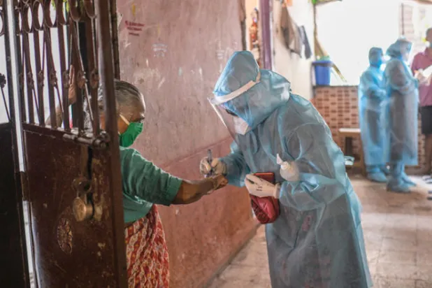 عاملة صحة تضع علامة على يد مصابة محتملة  (نيويورك تايمز)