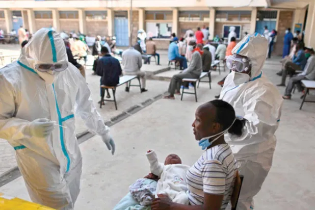 كينية وطفلها ينتظران الخضوع لفحص في نيروبي أمس (أ.ف.ب)