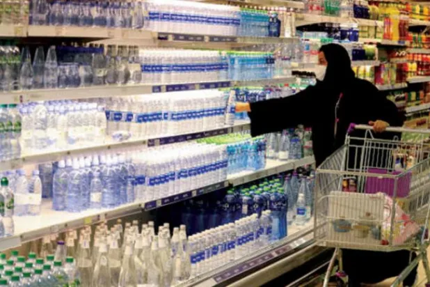 Suudi bir kadın maske zorunluluğuna uyarak bir alışveriş merkezinde alışveriş yapıyor (AFP)