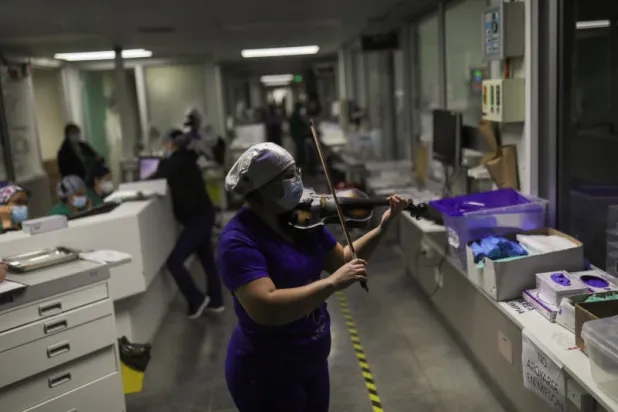 صور... ممرضة تعزف الكمان لمصابي «كورونا»