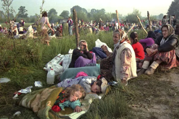 صورة تعود إلى يوليو (تموز) 1995 لهاربين من سريبرينيتسا يتجمعون في قاعدة للأمم المتحدة قرب مطار مدينة توزلا (أ.ب)