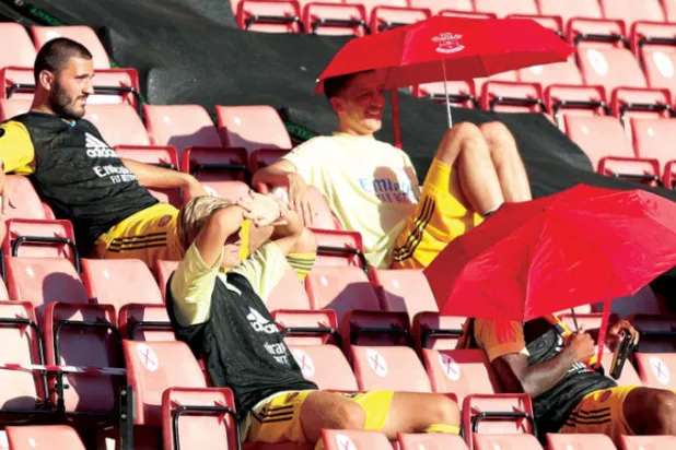 أوزيل  يتابع مباريات آرسنال من المدرجات تحت مظلة (رويترز)