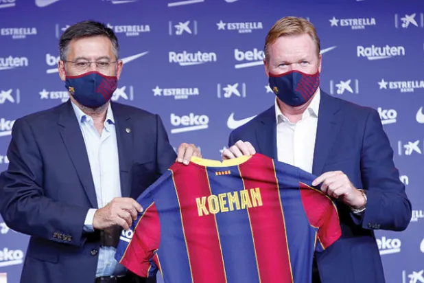 بارتوميو رئيس برشلونة (يسار) لدى تقديم المدرب الجديد كومان الذي فجر الأوضاع بالنادي (إ.ب.أ)