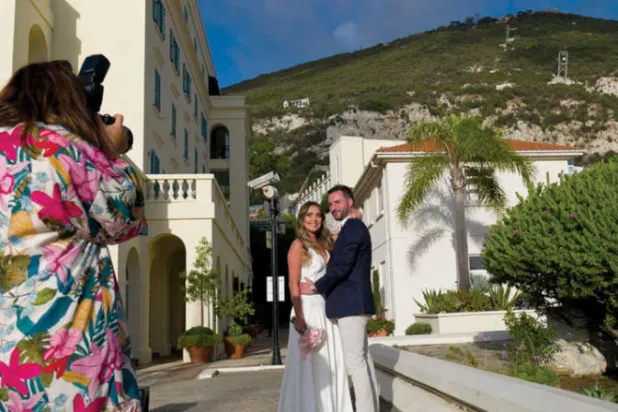 بريطاني وبرازيلية يلتقطان صورة الزواج في مارينا بجبل طارق