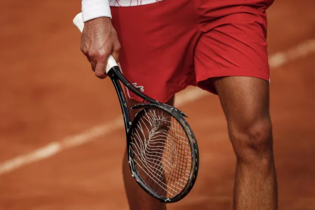 ديوكوفيتش يمسك بمضربه المحطم خلال مواجهة دومينيك كوفر في دور الثمانية ببطولة إيطاليا المفتوحة أمس (إ.ب.أ)