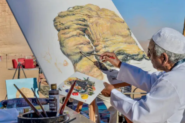 العبيد أثناء رسمه لإحدى لوحاته في المعارض المفتوحة (الشرق الأوسط)