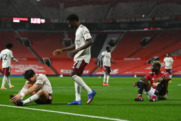 بوغبا لاعب يونايتد (على الأرض يمين) بعد مخالفة ضد بيليرين تسببت في ركلة جزاء لصالح آرسنال (رويترز)