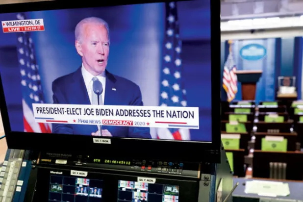 شاشة تنقل خطاب نصر بايدن في غرفة المؤتمرات بالبيت الأبيض مساء السبت (إ.ب.أ)