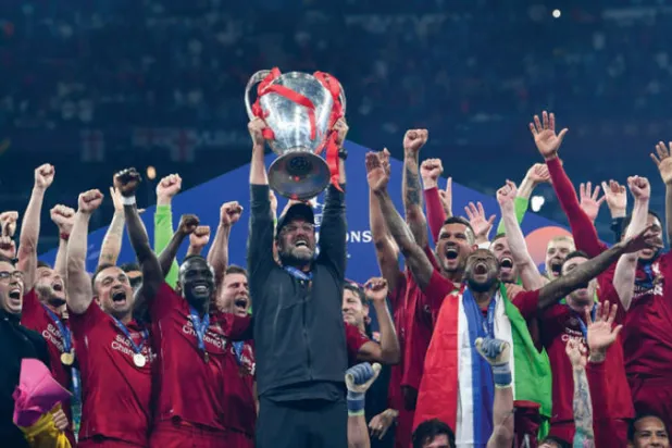 كلوب يحمل كأس أبطال أوروبا بين لاعبي ليفربول عام 2019 (أ.ف.ب)