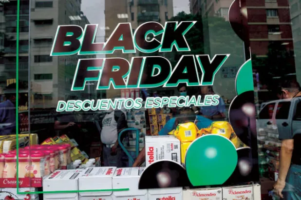 ملصقات تعلن عن تخفيضات "الجمعة السوداء" على واجهة أحد محلات مركز تسوق فب كاراكاس بفنزويلا (إ.ب.أ)