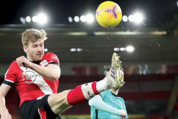 أرمسترونغ لاعب ساوثهامبتون يشتت كرة في مواجهة ليفربول لينتزع فريقه انتصاراً مثيراً (إ.ب.أ)