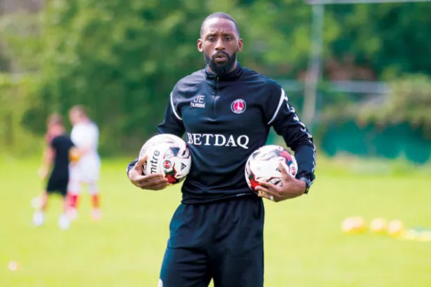 المدير الفني الجامايكي جيسون إيويل يجهز الكرات قبل بدء تدريب لاعبي تشارلتون للشباب