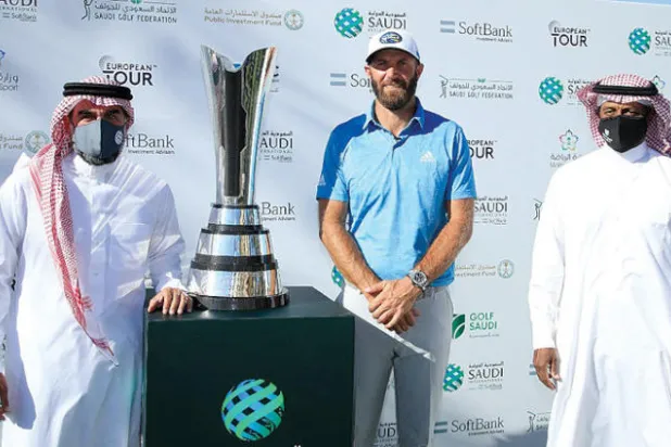 ياسر الرميان خلال تتويجه جونسون بكأس البطولة السعودية الدولية للغولف أمس (الشرق الاوسط)