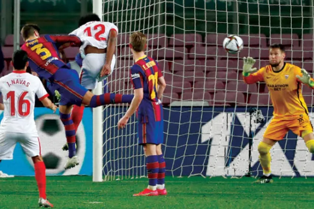 بيكيه (بالقميص رقم 3) يسجل برأسه هدف برشلونة الثاني في مرمى إشبيلية (أ.ب) 