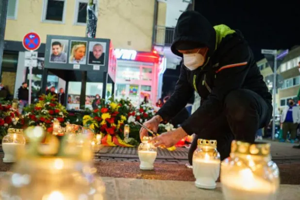 19 Şubat'ta Hanau Katliamı’nın anısına mum yakan bir Alman. (AP)