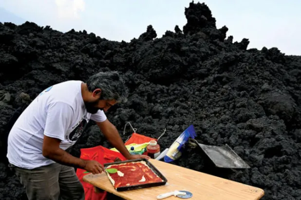 يحضر ديفيد غارسيا البيتزا للطهي على الحمم البركانية في غواتيمالا (أ.ف.ب)