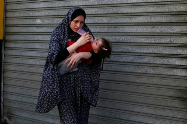 رہائشی عمارت کو نشانہ بنائے جانے سے پہلے ایک ماں کو اپنا بچہ لے کر فرار ہوتے ہوئے دیکھا جا سکتا ہے (اے بی)