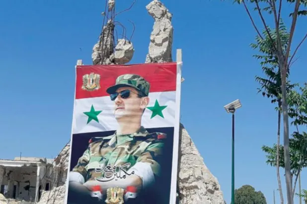 İktidardaki Baas Partisi tarafından Humus’ta Devlet Başkanı Esed’i desteklemek için asılan bir pankart