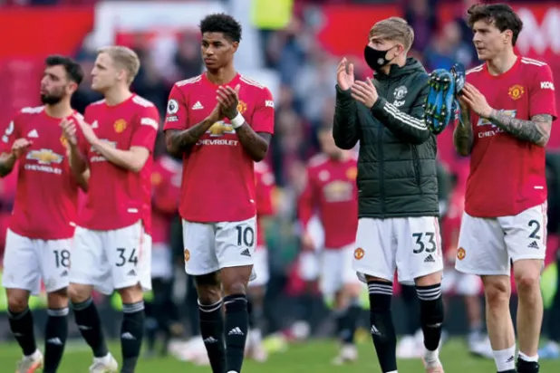 لاعبو يونايتد يحيون جماهيرهم العائدة للمرة الأولى منذ أكثر من 14 شهراً بعد مواجهة فولهام (أ.ب)