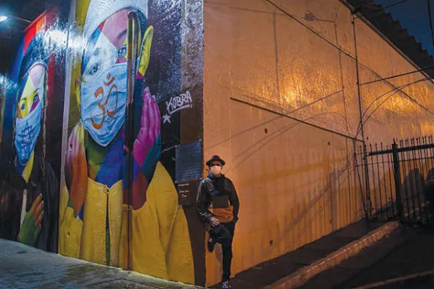 الفنان إدواردو كوبرا أمام جدارية رسمها لتكريم ضحايا «كوفيد - 19» في ساو باولو (تصوير: فيكتور مورياما)