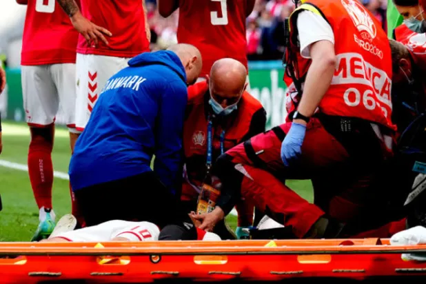 الدنماركي كريستيان إريكسن على الأرض يتلقى الإسعافات في لقطة أثارت رعب المتابعين (أ.ب)