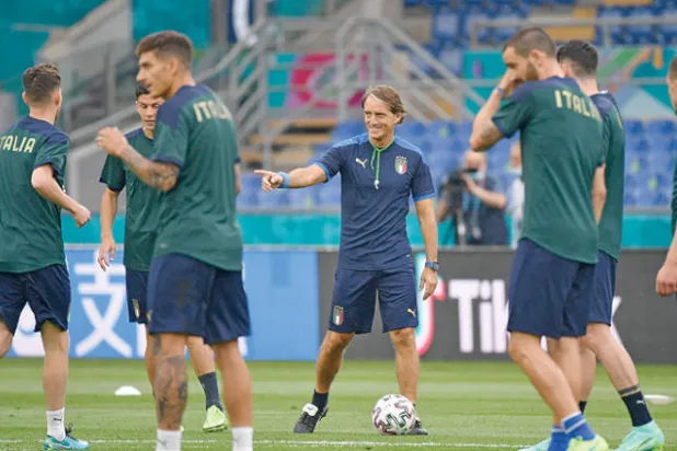 مانشيني مدرب إيطاليا (وسط) يوجه لاعبيه متطلعاً لحسم التأهل للدور الثاني من بوابة سويسرا (أ.ف.ب)