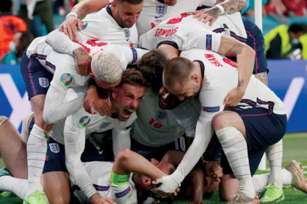 لاعبو إنجلترا يحتفلون بهاري كين (على الأرض) مسجل هدف الانتصار على الدنمارك (أ.ب)