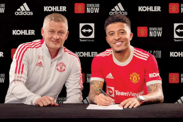 سانشو بجوار مدربه الجديد سولسكاير خلال التوقيع على عقد انضمامه ليونايتد (غيتي)