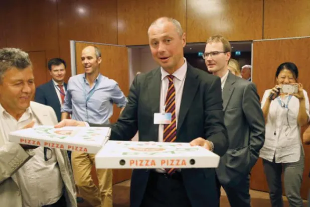 2016 yılının Eylül ayında Cenevre’de gazetecilere pizza dağıtan Rus yetkili Alexander Zorin (AFP)