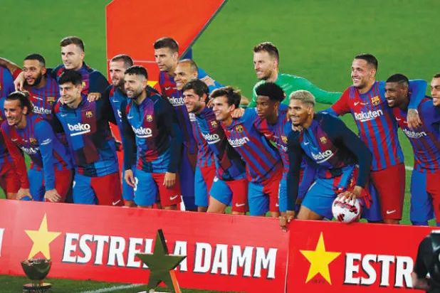 لاعبو برشلونة يحتفلون بكأس غامبر بعد الفوز  على يوفنتوس في أول لقاء من دون ميسي (أ.ب)