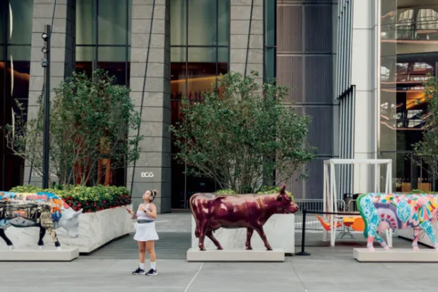 بعض الأبقار الملونة أمام مجمع تجاري في المدينة