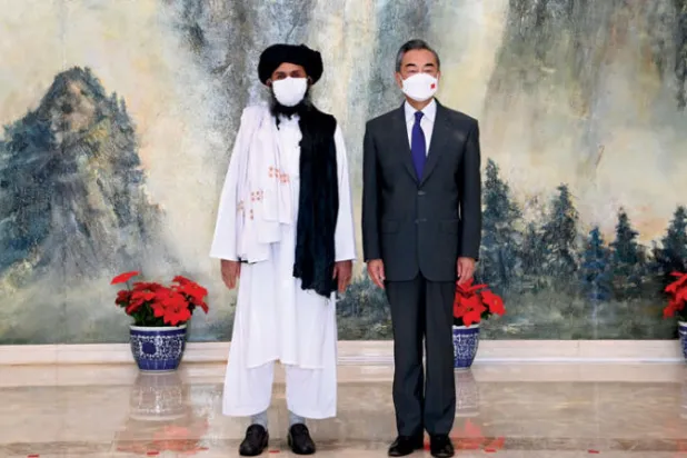 قيادي «طالبان» عبد الغني برادر ووزير الخارجية الصيني وانغ يي في بكين 28 يوليو الماضي (أ.ب)