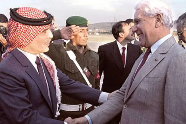 الملك حسين مستقبلاً الرئيس الجزائري الراحل الشاذلي بن جديد أثناء قمة عمّان 1987 (غيتي)