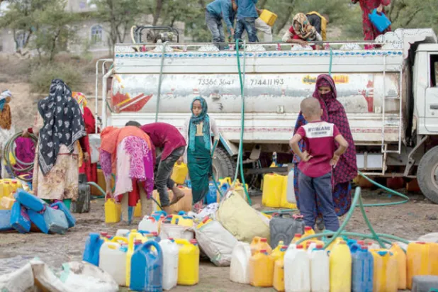 يمنيات يملأن غالونات بالمياه في  تعز (أ.ف.ب)