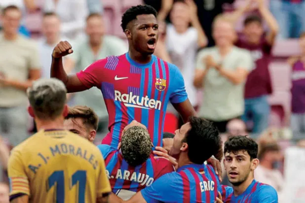 لاعبو برشلونة يحملون فاتي بعد عودته المظفرة إثر الإصابة (إ.ب.أ)