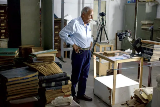 شهيد زيدي محاطاً بالصور التي التقطها والده لقادة باكستان الأوائل وشعبها في عهد تأسيس البلاد (نيويورك تايمز)