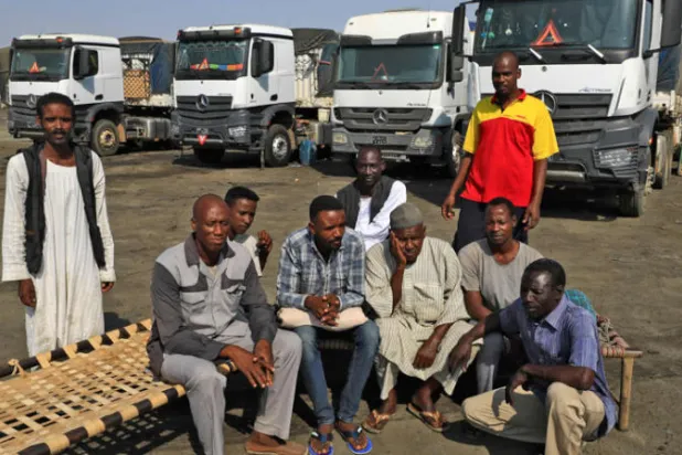 سائقو شاحنات قرب بورتسودان بعد إغلاق الطرق المؤدية للميناء مما سبب أزمات في السلع الأساسية (أ.ف.ب)