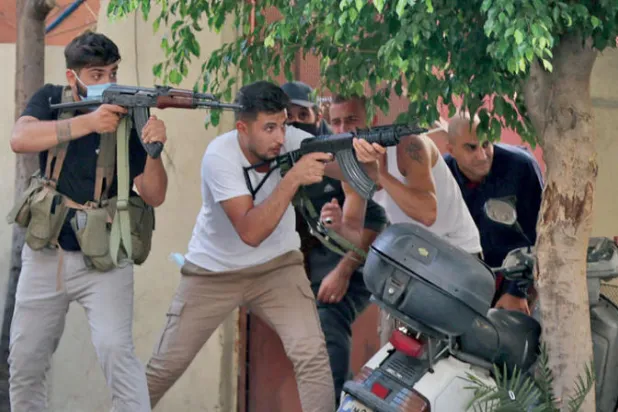 مقاتلون من «الثنائي الشيعي» خلال الاشتباكات الأخيرة في منطقة الطيونة (أ.ف.ب)