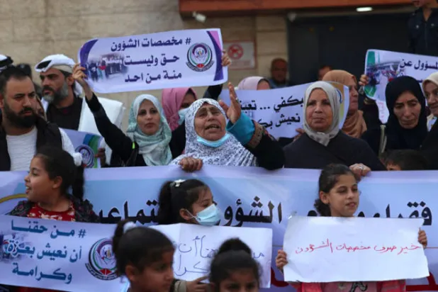 فلسطينيون يشاركون في احتجاج أمام مقر برنامج الأمم المتحدة الإنمائي في غزة خلال زيارة قام بها وفد أوروبي للمدينة أمس (أ.ف.ب)