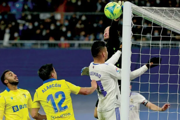 ليديسما حارس قادش يبعد الكرة قبل أن تصل إلى رأس كاسيميرو لاعب الريال (أ.ف.ب)