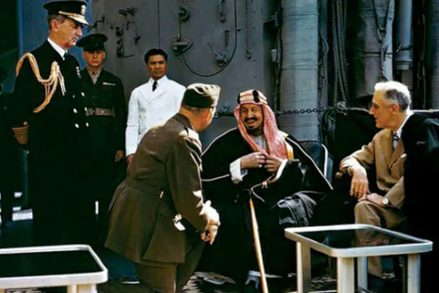 الملك عبد العزيز والرئيس روزفلت ويبدو بينهما العقيد وليام إيدي (جاثيا) والأدميرال وليام ليهي (الشرق الأوسط)
