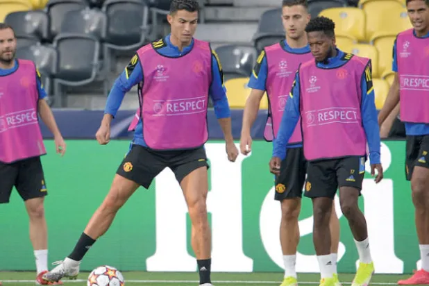 رونالدو نجم يونايتد يسيطر على الكرة بين زملائه في التدريب قبل مواجهة أتلتيكو (أ.ف.ب)