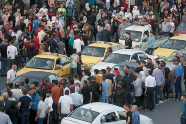 Suriyeliler Salı günü Şam'daki "Başkan Köprüsü"nde toplanarak cumhurbaşkanlığı affıyla serbest bırakılan mahkumların gelişini bekliyor (AP)