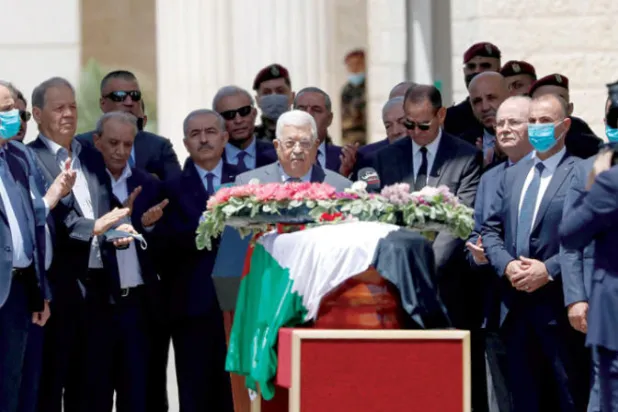 الرئيس محمود عباس يضع إكليل زهور على جثمان شيرين أبو عاقلة في رام الله بالضفة (رويترز)