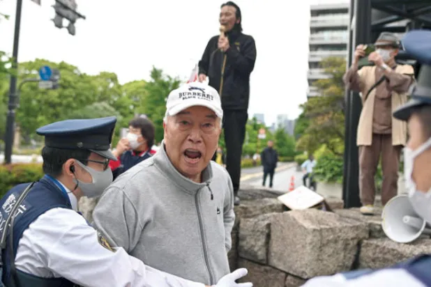 متظاهر ياباني يلقي شعارات بالقرب من مسيرة مناهضة للقواعد العسكرية الأميركية، في طوكيو أمس (أ.ف.ب)